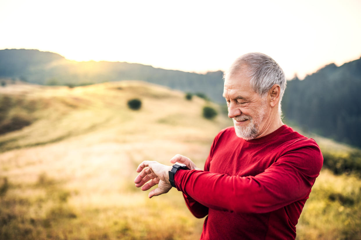 An old male happy sportsperson standing and resting after the run.