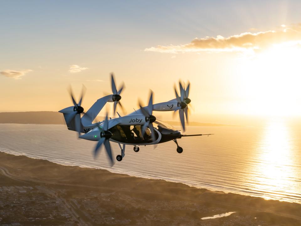 Joby eVTOL flying with sunset in background.