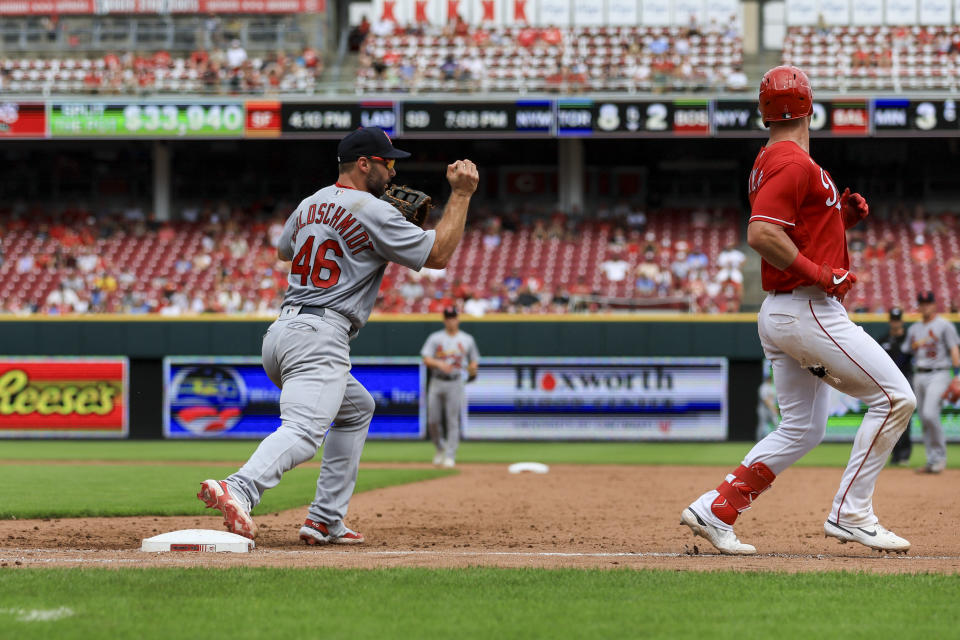 St. Louis Cardinals' Paul Goldschmidt, left, controls the ball as Cincinnati Reds' Matt Reynolds grounds out during the sixth inning of a baseball game in Cincinnati, Sunday, July 24, 2022. (AP Photo/Aaron Doster)