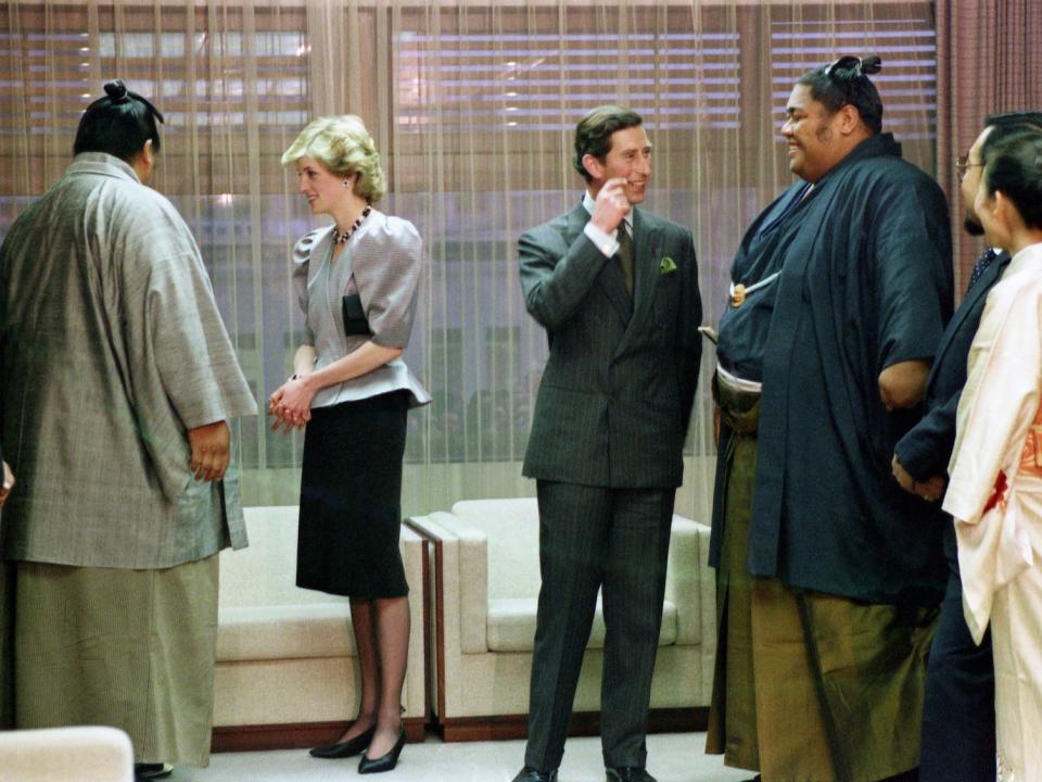 Prince Charles, the Prince of Wales, and Princess Diana, the Princess of Wales, talk to high-ranking sumo wrestlers during their visit to Kokugikan National Sumo arena in downtown Tokyo, Japan on May 11, 1986. The British Royal couple watched some of the opening day matches from the VIP box. The two wrestlers are Champion O'nukuni, left, and Hawaiian-born junior champion Konishiki.