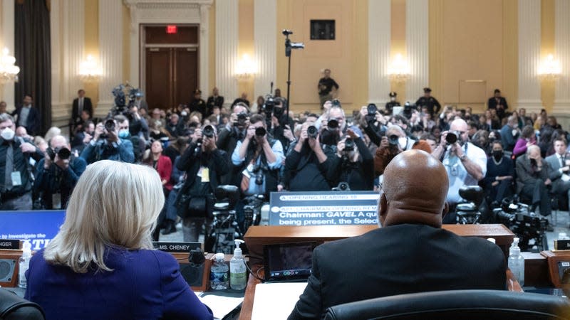 The Jan. 6 committee heads staring at a wall of reporters holding camears.