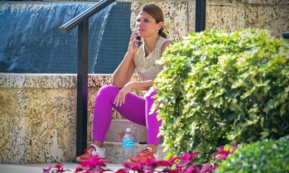 Nancy Pastor viendo cómo el FBI y la policía trabajan en la escena frente a la casa del urbanizador de Miami Sergio Pino en la comunidad Cocoplum de Coral Gables, la Florida, el martes 16 de julio de 2024.