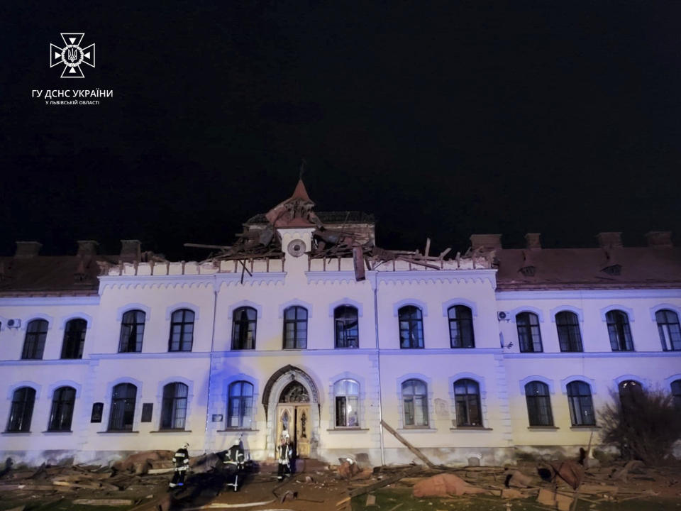 In this photo provided by the Ukrainian Emergency Service, firefighters work on the site of a univercity building damaged after a drone Russian attack in Dublyany, Lviv region, Ukraine, Monday, Jan. 1, 2024. (Ukrainian Emergency Service via AP)