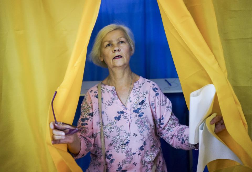 A woman leaves a booth at a polling station during at a parliamentary election in Kiev, Ukraine, Sunday, July 21, 2019. The party of new President Volodymyr Zelenskiy is widely predicted to get the largest share of votes in Sunday‚Äôs election. (AP Photo/Evgeniy Maloletka)