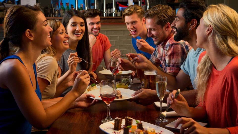 Group of friends enjoying food and drink in a bar.