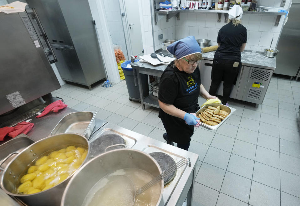 Ukrainian refugee women working at a Ukrainian food bar that a private foundation has opened to offer jobs to the refugees, in Warsaw, Poland, on Friday, April 1, 2022. Having escaped from Russian shelling, Ukrainian refugees are now focused on building new lives — temporarily or permanently. Countries neighboring their homeland, like Poland and Romania, are sparing no effort to help them integrate and feel needed in the new environment. (AP Photo/Czarek Sokolowski)