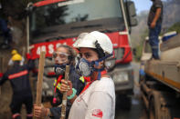 Turkish volunteers stand as they fight wildfires in Turgut village, near tourist resort of Marmaris, Mugla, Turkey, Wednesday, Aug. 4, 2021. As Turkish fire crews pressed ahead Tuesday with their weeklong battle against blazes tearing through forests and villages on the country's southern coast, President Recep Tayyip Erdogan's government faced increased criticism over its apparent poor response and inadequate preparedness for large-scale wildfires.(AP Photo/Emre Tazegul)