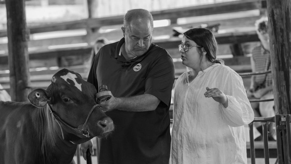 Gracie Lee, from eastern Indiana, talks with a farmer as they prepare for a dairy cattle show.