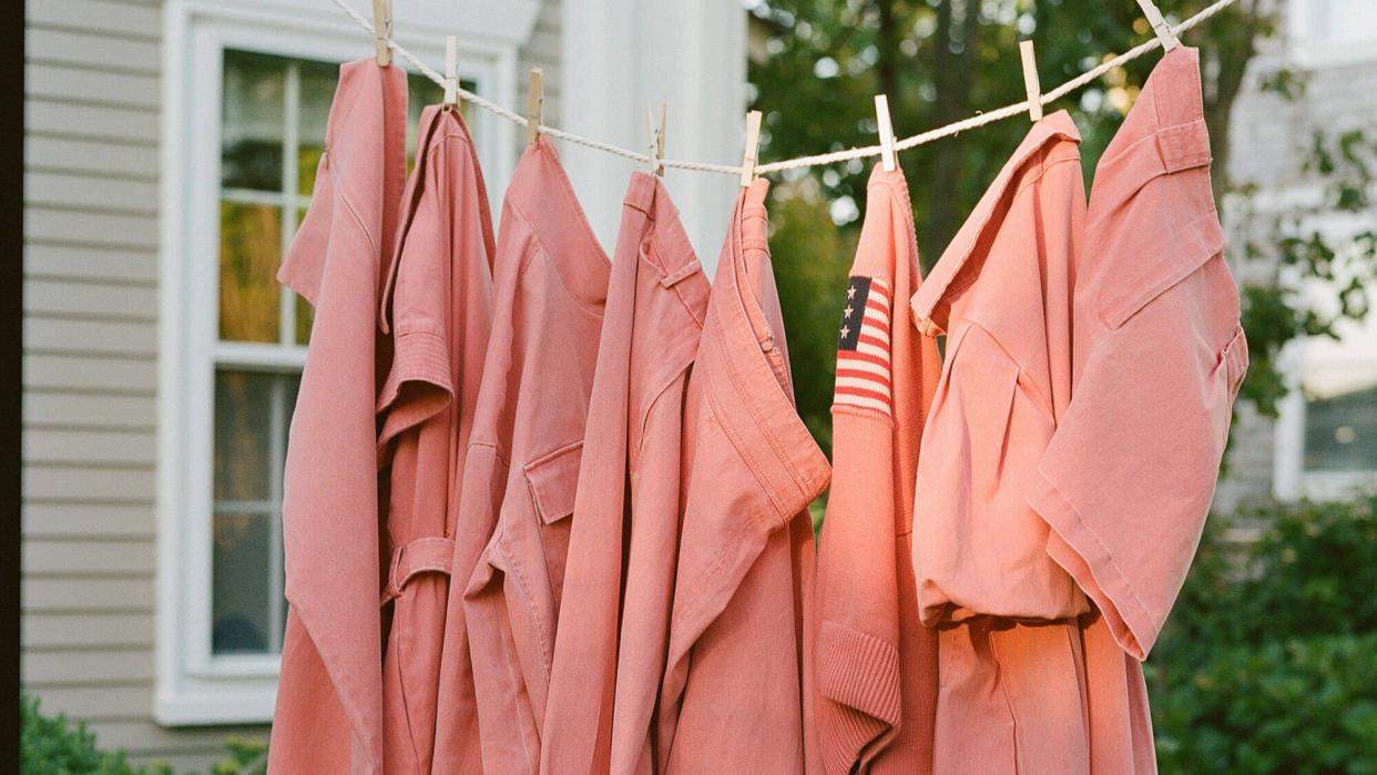 a group of pink umbrellas from a string outside of a house