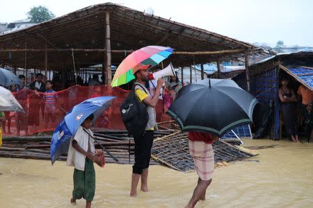 A volunteer of Bangladesh Red Crescent Society speaks to the Rohingya refugees who have missing relatives in Myanmar or other countries, in Kutupalong camp, in Cox's Bazar, Bangladesh, July 4, 2018. Picture taken July 4, 2018. REUTERS/Mohammad Ponir Hossain