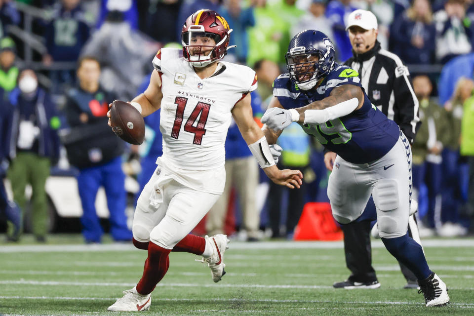 Washington Commanders quarterback Sam Howell (14) escapes a sack by Seattle Seahawks defensive end <a class="link " href="https://sports.yahoo.com/nfl/players/28394" data-i13n="sec:content-canvas;subsec:anchor_text;elm:context_link" data-ylk="slk:Leonard Williams;sec:content-canvas;subsec:anchor_text;elm:context_link;itc:0">Leonard Williams</a> (99). Mandatory Credit: Joe Nicholson-USA TODAY Sports