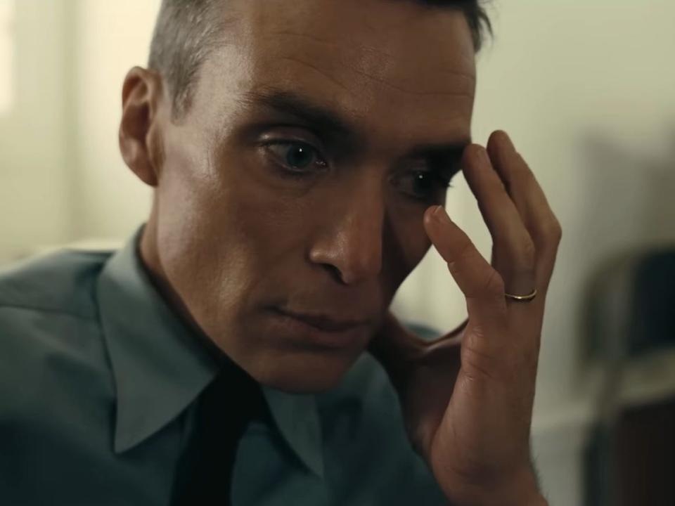 Cillian Murphy in a scene from "Oppenheimer" where J. Robert Oppenheimer is sitting with his head in his hands.