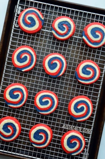 red, white, and blue pinwheel icebox cookies on a wire cooling rack