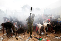 <p>People fall as police fire tear gas to try control a crowd trying to force their way into a stadium to attend the inauguration of President Uhuru Kenyatta at Kasarani Stadium in Nairobi, Kenya, Nov. 28, 2017. (Photo: Baz Ratner/Reuters) </p>