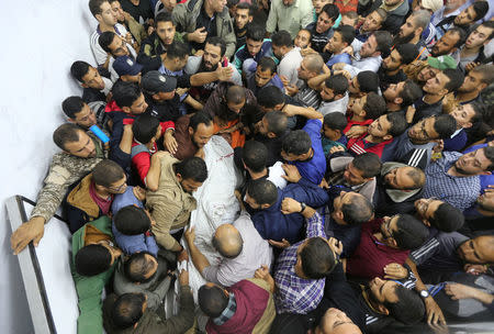 People carry the body of a Palestinian who was killed near the border between Israel and central Gaza Strip October 30, 2017. REUTERS/Ibraheem Abu Mustafa