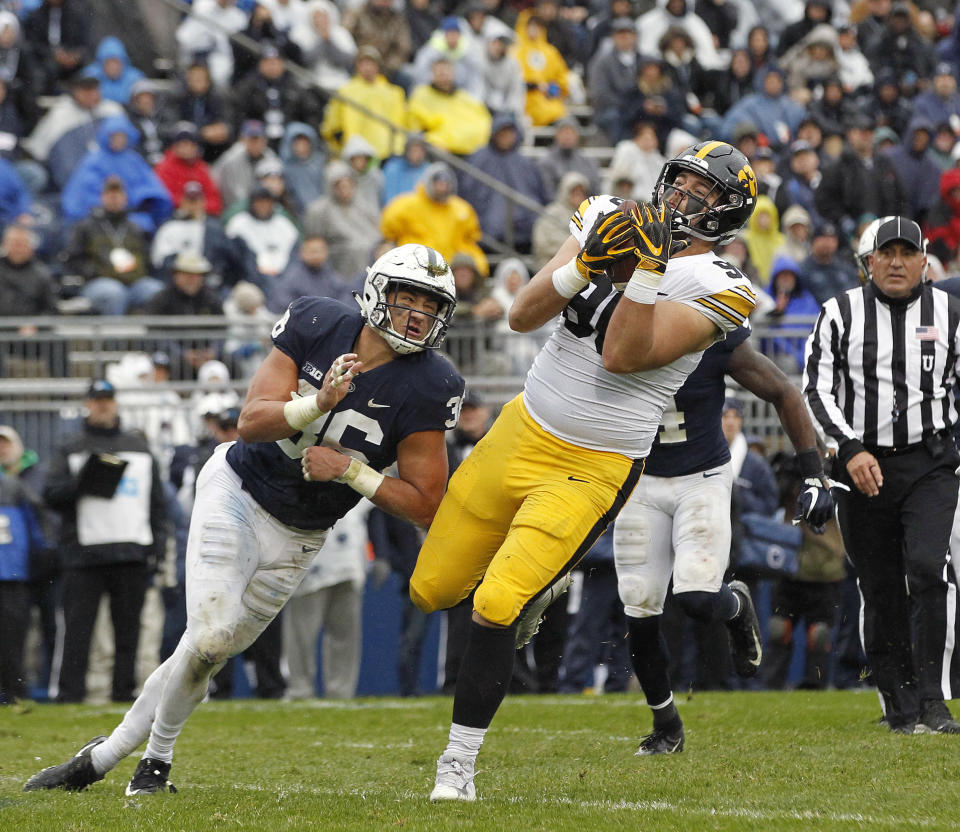 Iowa's Sam Brincks (90) catches a touchdown pass as Penn State's Jan Johnson (36) defends during the first half of an NCAA college football game in State College, Pa., Saturday, Oct. 27, 2018. (AP Photo/Chris Knight)