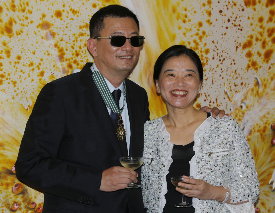 Hong Kong director Wong Kar-wai, left, and his wife Esther smile after he received the Commandeur des Arts et Lettres from French Foreign Minister Laurent Fabius, in Hong Kong Sunday, May 5, 2013. Wong has been given France's highest cultural honor. (AP Photo/Vincent Yu)