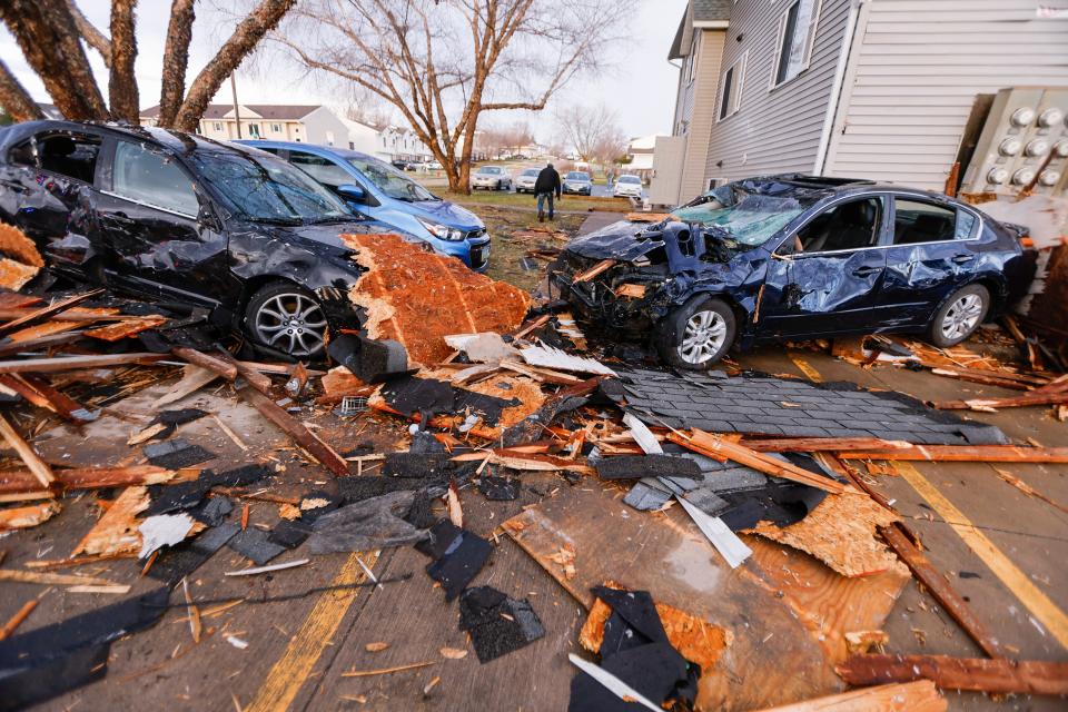 Debris litters a parking lot and vehicles are seen thrown around after a tornado touched down near the intersection of 23rd Avenue and Ninth Street in Coralville, Iowa, Friday, March 31, 2023. City crews, residents and neighbors worked to clear debris off the roadway and vehicles. (Jim Slosiarek/The Gazette via AP)