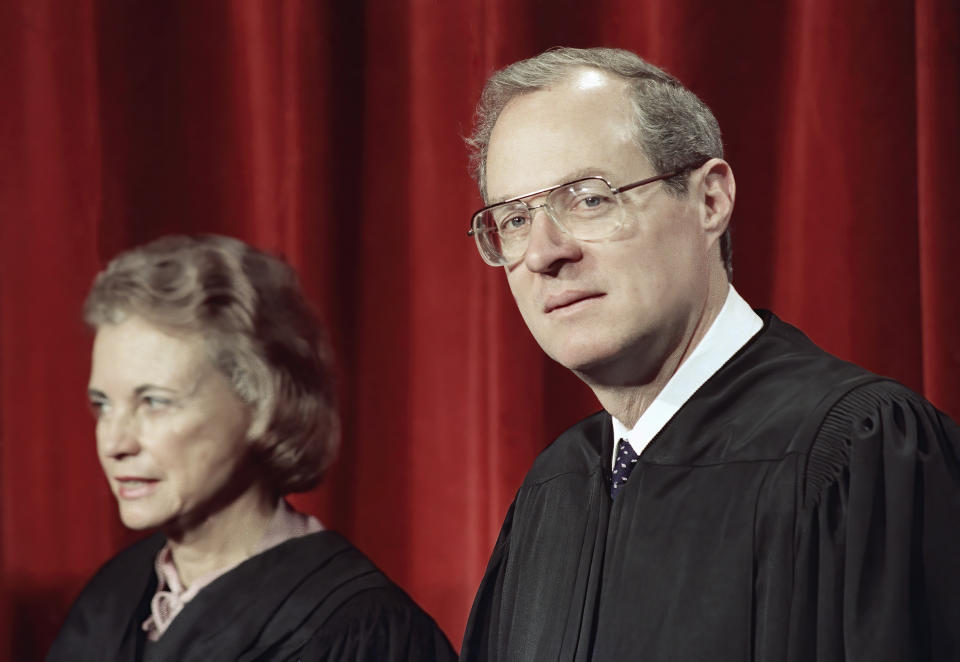 FILE - Justice Anthony Kennedy, the newest member of the Supreme Court, and Justice Sandra Day O'Connor, are shown on April 15, 1988, in Washington, at the Supreme Court during a picture taking session. The full court was also present for the photo session. For years, the Supreme Court moved to the left or right only as far as Justices O'Connor and Kennedy allowed. They held pivotal votes on a court closely divided between liberals and conservatives. Now, though, a more conservative court that includes two men who once worked for Kennedy is taking direct aim at major opinions written by the two, now retired, justices.(AP Photo/Bob Daugherty, File)