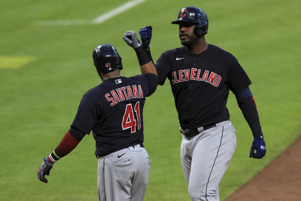 Cleveland Indians' Carlos Santana (41) celebrates the two-run home run hit by Franmil Reyes (32) in the eighth inning during a baseball game against the Cincinnati Reds in Cincinnati, Tuesday, Aug. 4, 2020. (AP Photo/Aaron Doster)