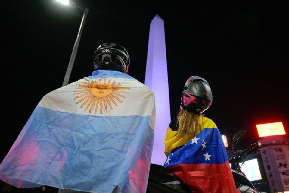 Dos simpatizante de Javier Milei con las banderas argentina y venezolana.