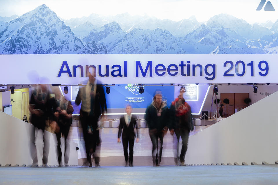 People walk up stairs at the congress center where the annual meeting of the World Economic Forum 2019, WEF, take place in Davos, Sunday, Jan. 20, 2019. (AP Photo/Markus Schreiber)