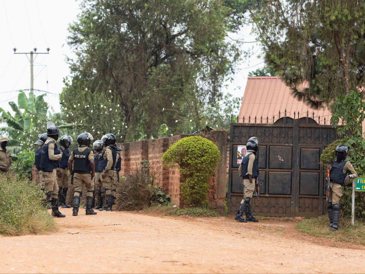 <p>Security forces are seen blocking the entrance to opposition leader Bobi Wine’s property on Saturday</p> (Getty)