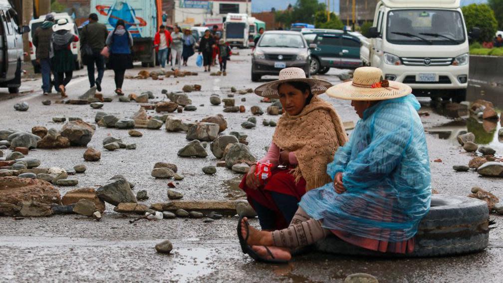 Dos mujeres campesinas en un corte de rutas. 