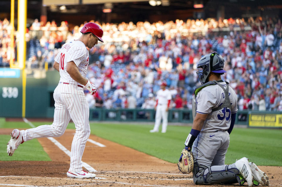 Philadelphia Phillies' J.T. Realmuto, left, comes in to score on his two-run home run as Colorado Rockies catcher Elias Diaz, right, looks on during the first inning of a baseball game, Tuesday, April 16, 2024, in Philadelphia. (AP Photo/Chris Szagola)