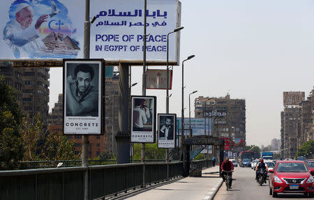 Vehicles drive past a billboard ahead of Pope Francis' visit in Cairo, Egypt April 26, 2017. REUTERS/Amr Abdallah Dalsh