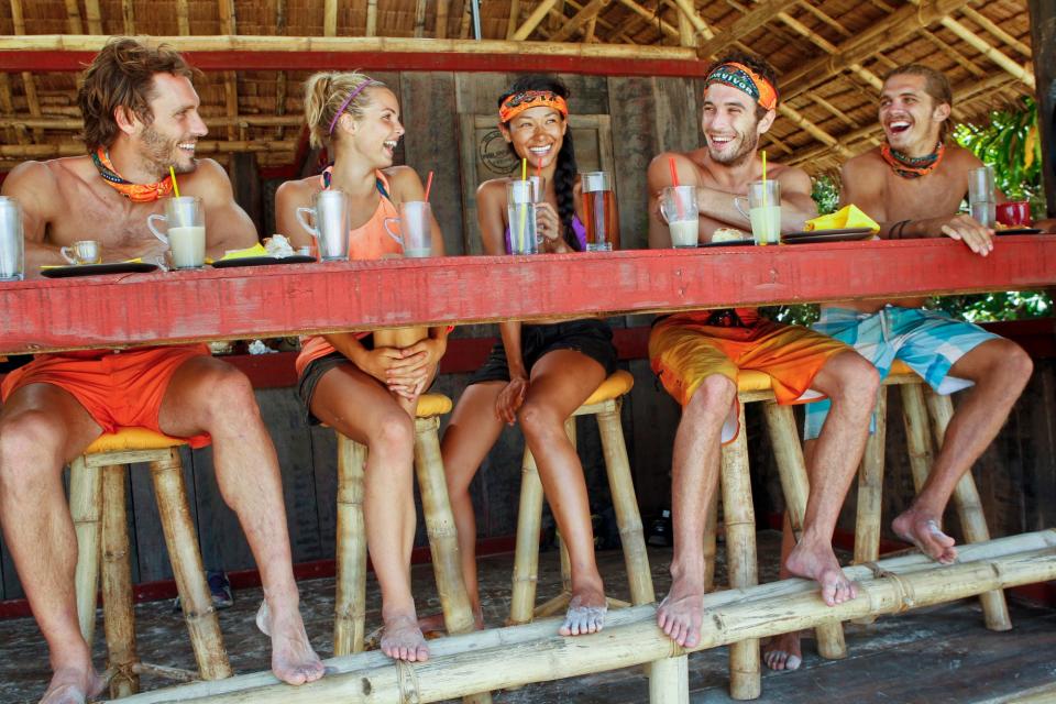 "Survivor — Fans vs. Favorites" players sitting at a bartop with drinks.