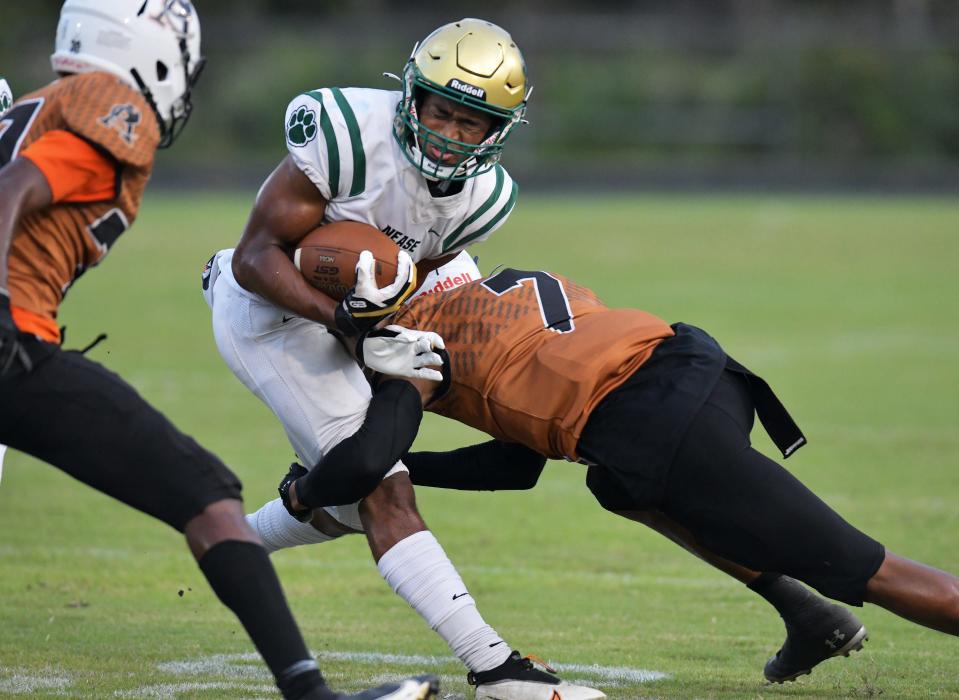 Nease wide receiver Dom Henry (1) catches a pass while absorbing a hit against Atlantic Coast during a September 2021 game.