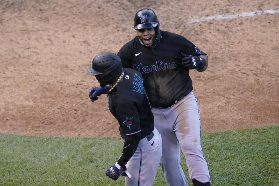 Starling Marte (primer plano) y Jesús Aguilar (derecha) celebran tras el jonrón de dos carreras para los Marlins de Miami en el primer juego de la serie de wildcards de la Liga Nacional, el miércoles 30 de septiembre de 2020. (AP Foto/Nam Y. Huh)