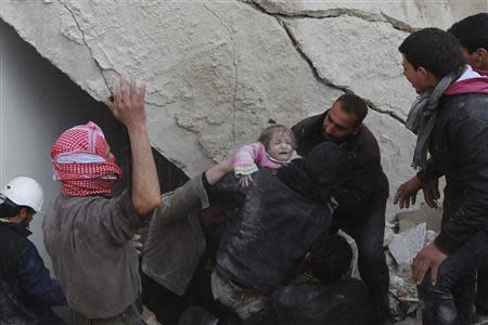 A child is rescued from under the rubble of a collapsed building in the Maysar neighbourhood of Aleppo December 28, 2013. REUTERS/Jalal Alhalabi