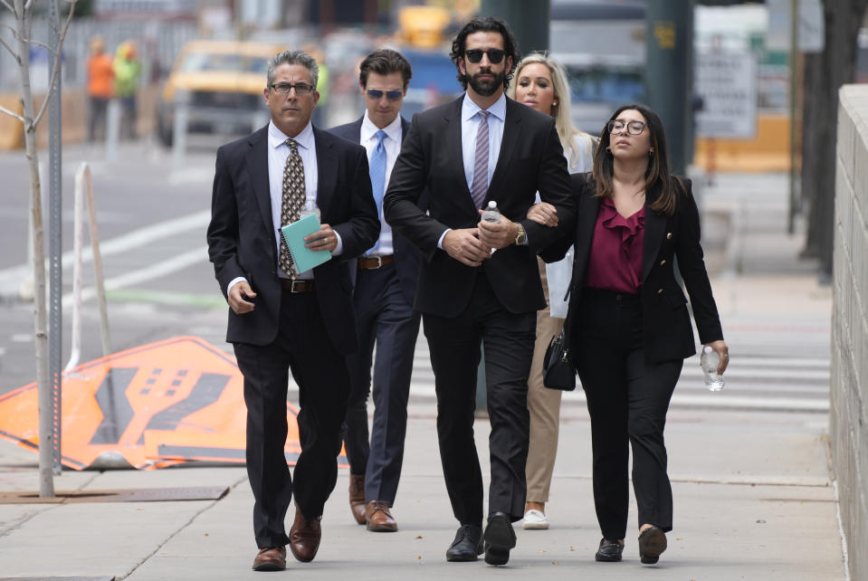 Defense attorneys for Pittsburgh dentist Lawrence "Larry" Rudolph head into federal courthouse with the dentist's children for the afternoon session of the trial, Wednesday, July 13, 2022, in Denver. (AP Photo/David Zalubowski)