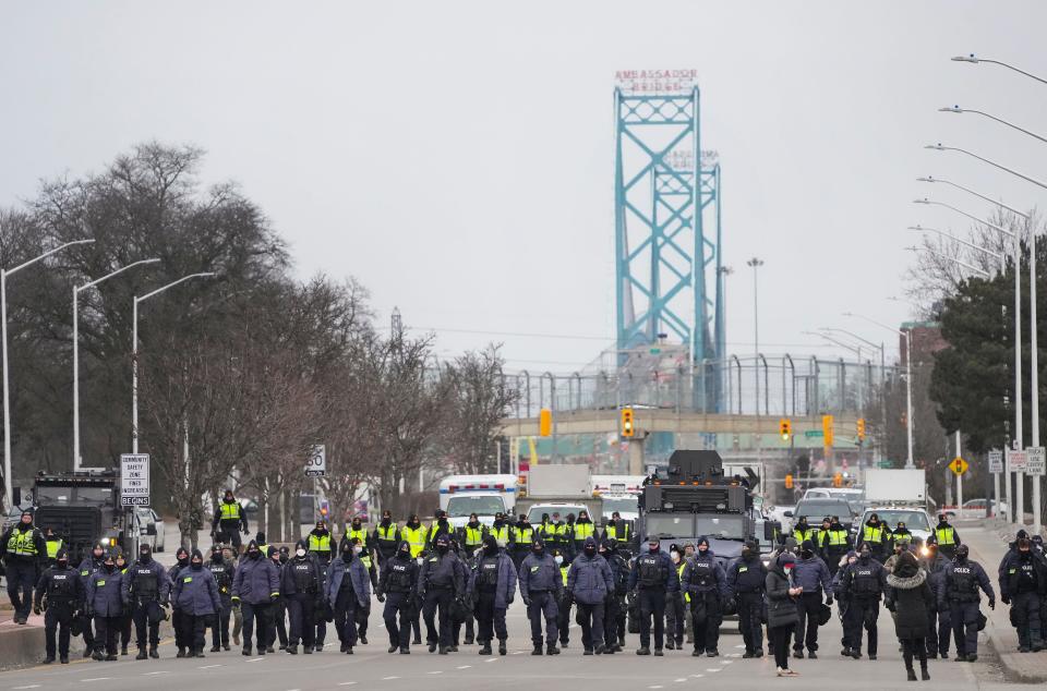 Police walk the line to remove all truckers and supporters after a court injunction gave police the power to enforce the law after protesters blocked the access leading from the Ambassador Bridge, linking Detroit and Windsor, as truckers and their supporters continue to protest against COVID-19 vaccine mandates and restrictions in Windsor, Ontario, Sunday, Feb. 13, 2022. 