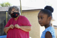 Zita Robinson, left, who's 77 and diabetic, looks at her granddaughter, 8-year-old Traris "Trary" Robinson-Newman, from a safe distance Tuesday, Aug. 4, 2020, in Phoenix. Robinson has been careful around her granddaughter amid the coronavirus pandemic. (AP Photo/Ross D. Franklin)