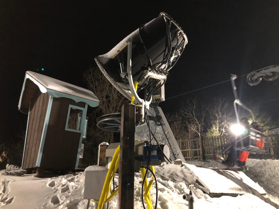 One of the new snow guns sits ready to fire up as skiers ride the "Triple" chair lift at Swiss Valley Ski & Snowboard Area in Jones on Monday, Jan. 8, 2024.