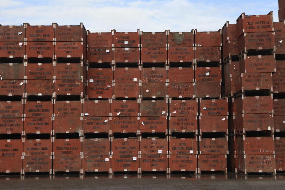 Fruit crates owned by Sandher Fruit Packers sit stacked at its headquarters in Kelowna, British Columbia, on Feb. 8, 2024. The fruit growing company is developing an orchard near a key wildlife corridor that ribbons around the Okanagan Mountain Provincial Park and Kalamalka Lake Provincial Park. (Aaron Hemens/IndigiNews via AP)