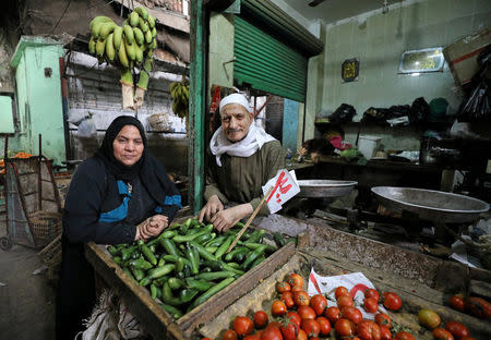 Hayes Mehana (R), 78, and Om Hany, 60, pose for a photograph at a vegetable market in Cairo, Egypt, February 12, 2018. The couple have been married for 42 years and have 12 children. Their love started at a vegetable market and now they dedicate their time to their 50-year-old vegetable shop business which they both worked to expand. "Our families don't know about Valentine's Day but we built a big family as it was our dream. With my wife, every day is like a festival, not just one day," Hayes said. REUTERS/Mohamed Abd El Ghany