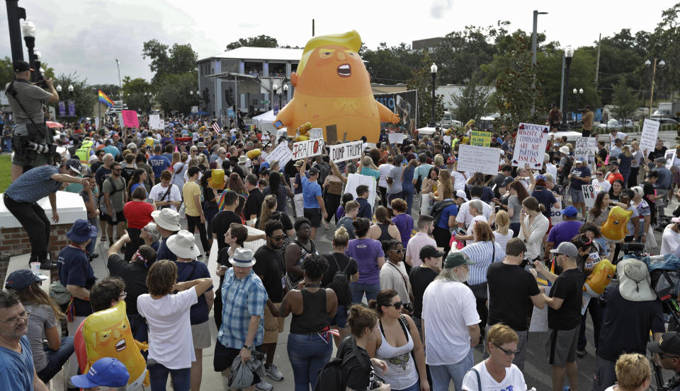 An inflatable Baby Trump balloon towers over protestors during a rally Tuesday, June 18, 2019, in Orlando, Fla. A large group protesting against President Donald Trump were rallying near where Trump was announcing his re-election campaign. President Trump is being trolled by an angry diaper-clad caricature armed with a cell phone. It’s Baby Trump, the blimp that has become synonymous with resistance to the American president. The balloon has been cloned multiples times over and become something of a celebrity _ for at least one slice of the U.S. electorate. He’s also emerged as a rallying point for supporters of the president who see the blimp as evidence of just how over-the-top the opposition has become.(AP Photo/Chris O'Meara)