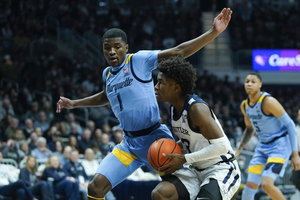 Butler's Chuck Harris (3) goes to the basket against Marquette's Kam Jones (1) during the first half of an NCAA college basketball game, Saturday, Feb. 12, 2022, in Indianapolis. (AP Photo/Darron Cummings)