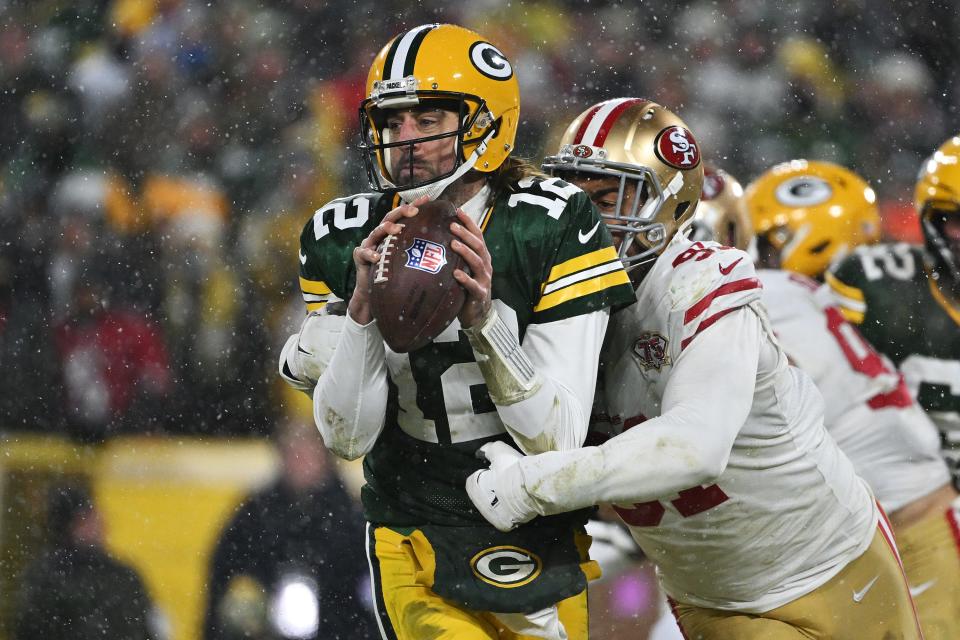 Quarterback Aaron Rodgers (12) of the Green Bay Packers is sacked by defensive end Arik Armstead (91) of the San Francisco 49ers during the 2nd quarter of the NFC Divisional Playoff game against the San Francisco 49ers at Lambeau Field on January 22, 2022, in Green Bay, Wisconsin.