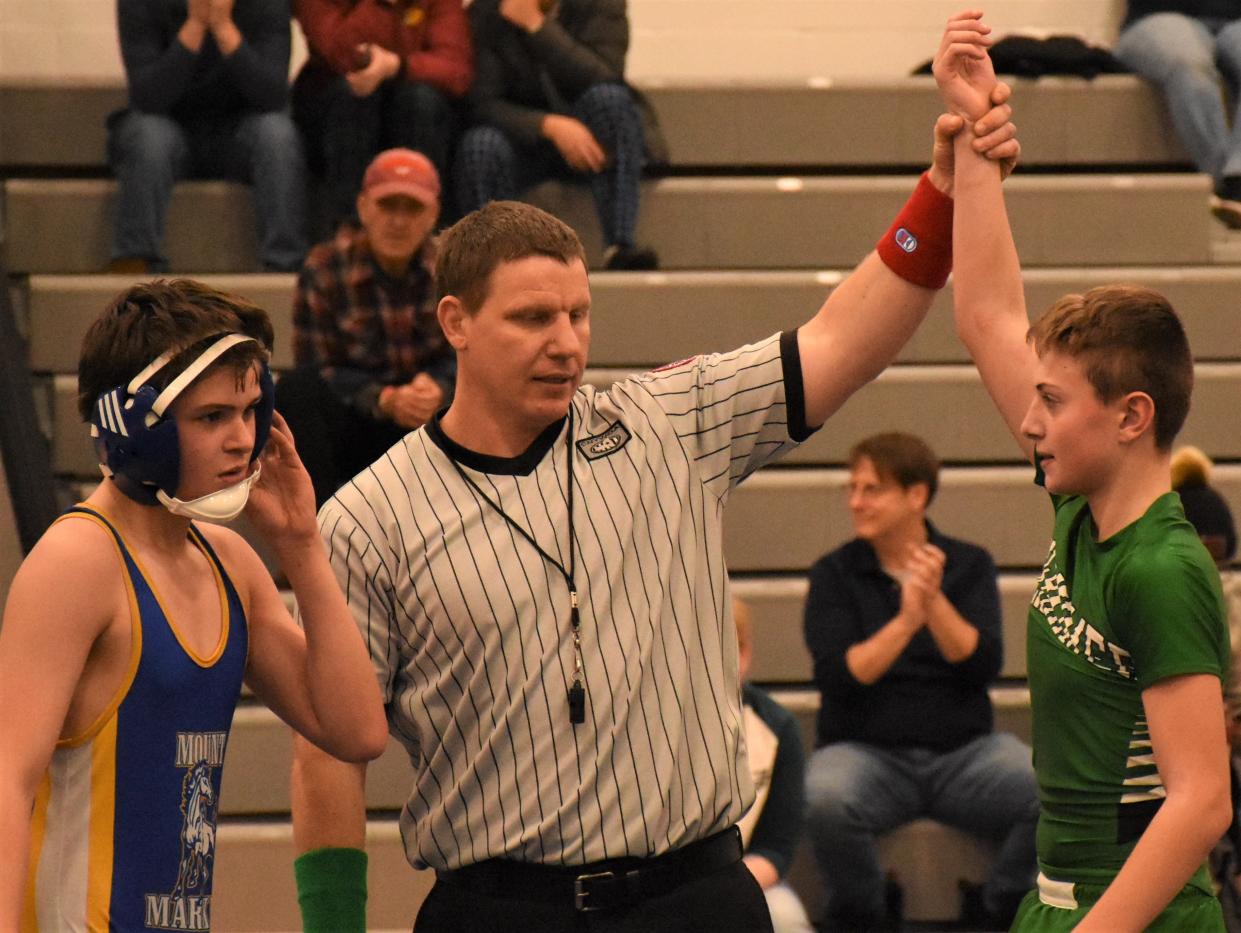 Referee Adam Jones (center) raises the arm of Herkimer seventh-grader Aldin Covic, signaling his victory after pinning his opponent with four seconds left in a Tuesday match against Mt. Markham.