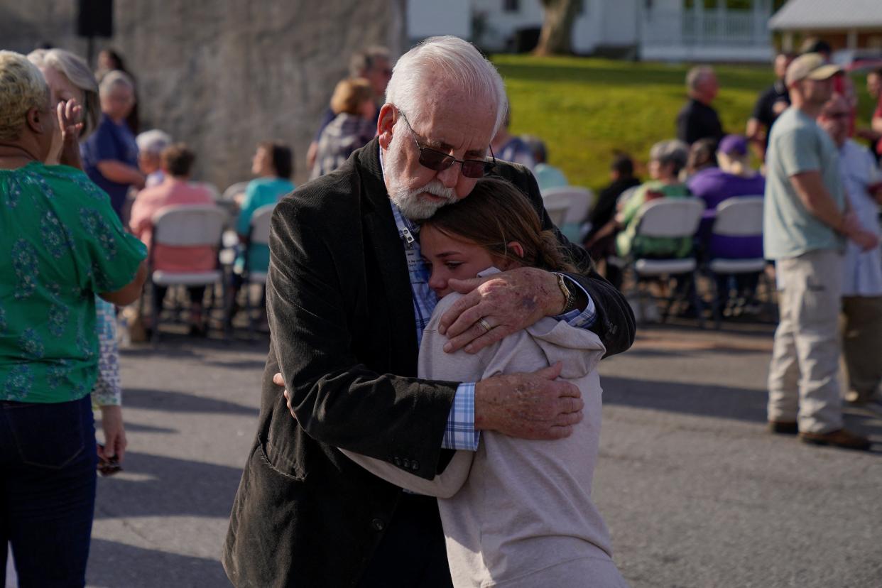 Community members embrace each other ahead of a vigil the day after a shooting during a teenager’s birthday party (Reuters)