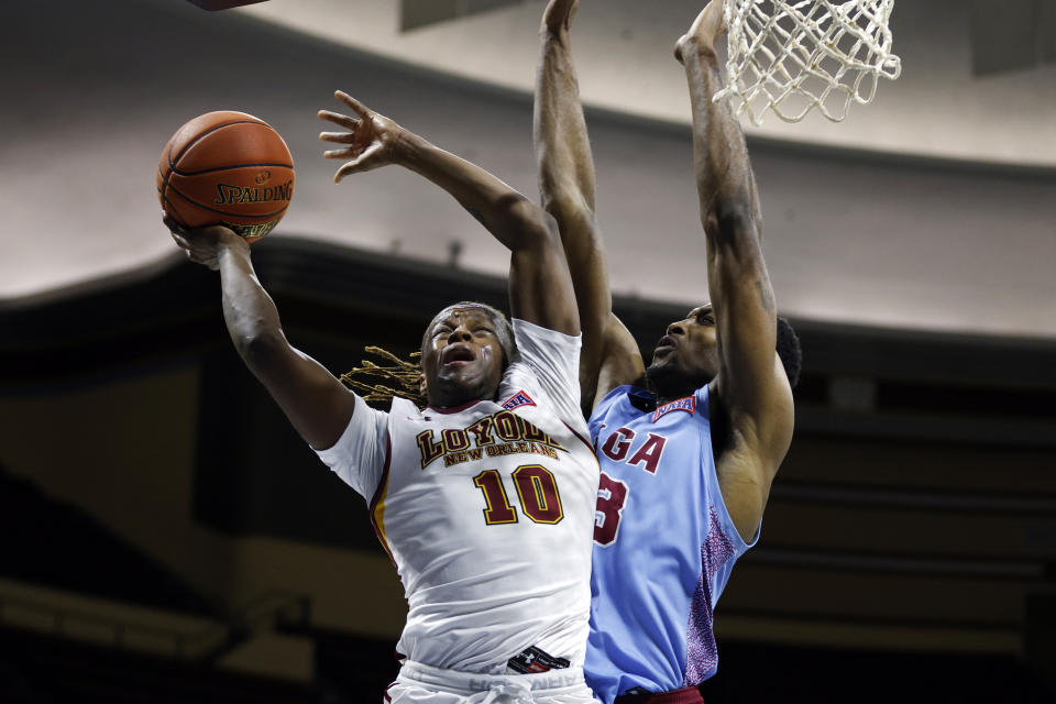 FILE - Loyola (La.) guard Brandon Davis (10) shoots against Talladega forward Camron Reece (33) during the second half of the NAIA men's championship college basketball game Tuesday, March 22, 2022, in Kansas City, Mo. Loyola won 71-56. Zach Wrightsil, Myles Burns and Davis withstood the obstacles surrounding Hurricane Ida’s arrival in New Orleans last year and helped Loyola-New Orleans win the NAIA championship. Now the three of them are trying to make a jump rarely attended by going directly from an NAIA program to an NCAA Division I school. (AP Photo/Colin E. Braley, File)