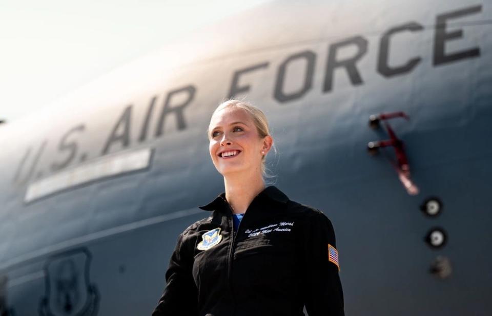 Madison Marsh smiles for a photo in front of an aircraft displaying "US Air Force."