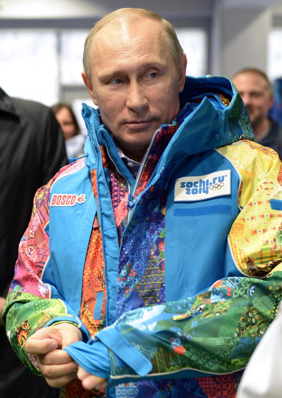 Russian President Vladimir Putin tries on a jacket during a visit the training center for volunteers Winter Olympics at the Black Sea resort of Sochi, southern Russia, Saturday, Jan. 4, 2014. Russian President Vladimir Putin has rescinded a blanket ban on demonstrations in Sochi in and around the Winter Olympics and Paralympics. (AP Photo/RIA-Novosti, Alexei Nikolsky, Presidential Press Service)