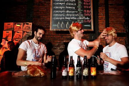 Bartenders fix their wigs as they impersonate Republican presidential nominee Donald Trump during a Mexican brewery booze-up in Mexico City, Mexico October 20, 2016. REUTERS/Carlos Jasso