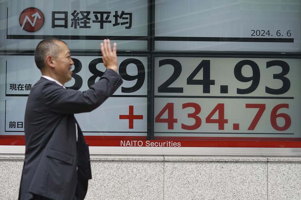 A person walks in front of an electronic stock board showing Japan's Nikkei 225 index at a securities firm Thursday, June 6, 2024, in Tokyo. (AP Photo/Eugene Hoshiko)